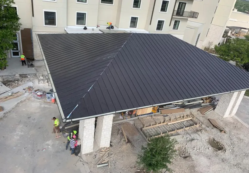 Metal roofing installation team working on a commercial building in Central